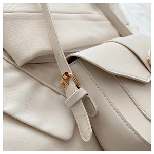 Gros plan sur la bandoulière réglable avec boucle en métal doré sur un sac blanc chic