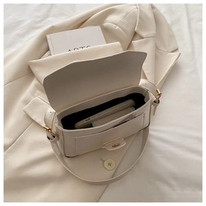 Détail de la capacité intérieure du sac bandoulière en cuir blanc cassé et boucles dorées