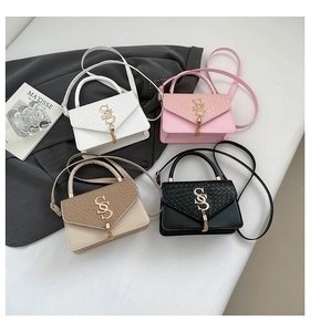 Detail view of colorful crossbody bags with crocodile texture and tassel charms