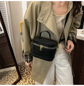 Sac bandoulière imprimé léopard porté sur un trench-coat kaki avec une sangle amovible