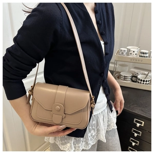 Vue détaillée du petit sac carré en cuir beige avec boucle porté par un mannequin