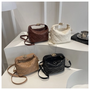 Quilted heart stitching detail on stylish tote bags in brown, white, khaki, and black