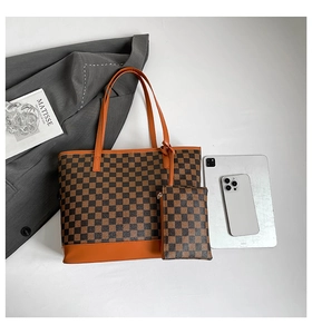 Detail of checkered tote bag with matching pouch and brown leather handles set