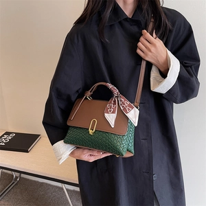 Women's chic contrast handbag with green woven texture and brown flap shown on a model