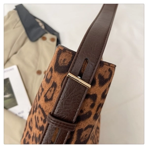 Detailed view of leopard print tote bag with soft suede texture and leather strap buckle