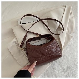 Detailed view of brown heart-quilted texture on elegant faux leather crossbody handbag
