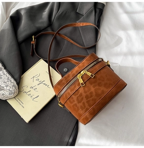 Detail der kamelfarbenen Box-Tasche mit Leopardenmuster und goldenem Reißverschluss