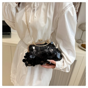 Detail view of shimmering black sequin clutch bag with vintage gold clasp and elegant chain