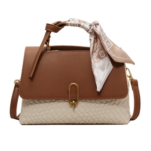 Chic two-tone handbag with scarf-wrapped handle and golden oval lock on white background