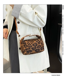 Détail du sac bandoulière léopard avec poignées en cuir marron et fermoir métallique
