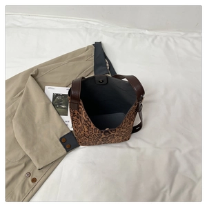 Top view of leopard print tote bag showing brown leather handles and magnetic closure detail