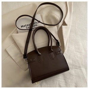 Detail of dark brown leather tote bag with reinforced handles and adjustable strap