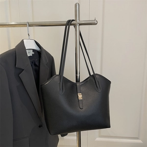 Classic black lychee pattern tote bag with gold buckle displayed on a minimalist background