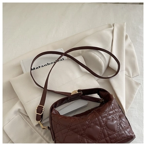 Detail of dark brown faux leather bag with heart quilted stitching and gold hardware
