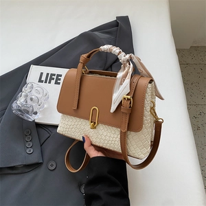Elegant woven cream and brown leather handbag with silk scarf on a grey suit
