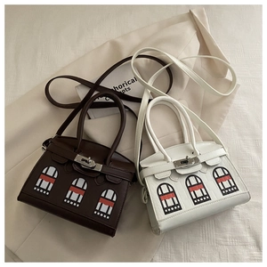 Detailed view of luxury trapezoid handbags in brown and white with house motif