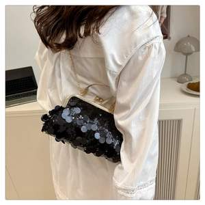 Detail of elegant black sequin evening bag with gold metal handle and vintage clasp