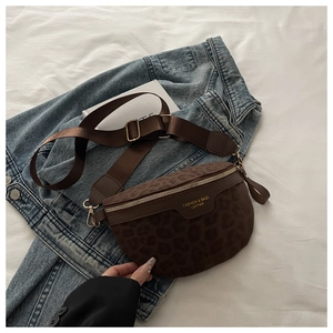 Détail du sac de poitrine léopard avec ferrures dorées et large bandoulière en nylon sur tissu