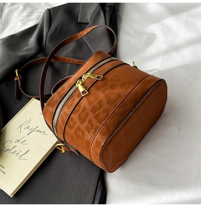 Detailansicht der braunen Tasche mit Leopardenmuster und goldenen Reißverschlüssen