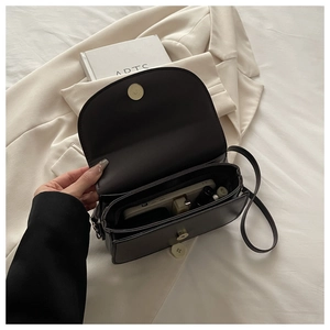 Interior view showing the dual compartments and storage capacity of the black shoulder bag