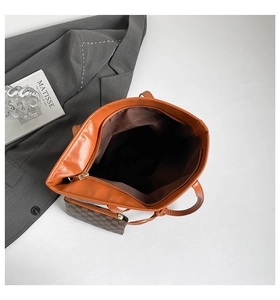Detailed interior of orange-brown tote bag with a checkered pouch and metal zipper