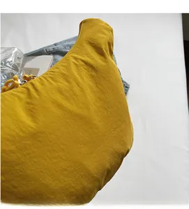 Close-up of bright yellow nylon crescent bag showing soft textured fabric and durability