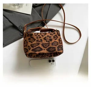 Comparaison de taille d'un sac à bandoulière en peluche léopard avec un smartphone