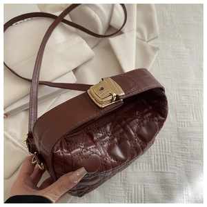 Detail shot of brown heart-quilted PU leather bag with premium gold metal buckle closure