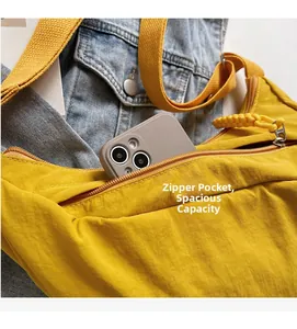 Detail of yellow nylon crossbody bag zipper pocket showing large capacity for smartphone