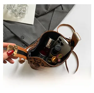 Vue détaillée de l'intérieur du sac léopard montrant la grande capacité et accessoires