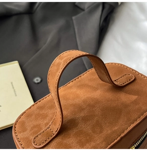 Detailansicht der Nähte und Wildledertextur dieser braunen Vintage-Handtasche
