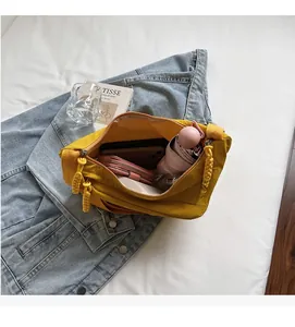 Spacious interior of yellow nylon crossbody bag showing storage for phone and umbrella
