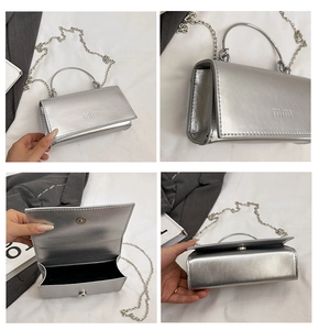 Macro view of silver mirror handbag showing metallic handle and magnetic closure