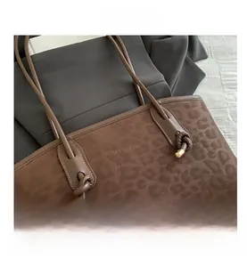 Close-up of leopard pattern texture on brown tote bag with metallic knot details