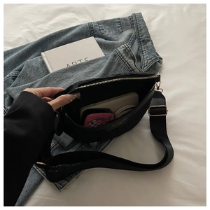 Détails de l'intérieur du sac bandoulière en nylon noir avec fermetures éclair dorées