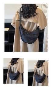Detail view of the black nylon half-moon crossbody bag with woven zipper pullers