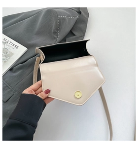 Detail view of the cream envelope bag interior with gold magnetic buckle and black lining