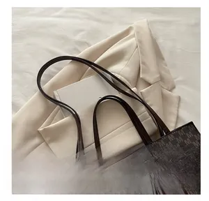 Close-up of comfortable shoulder straps on a deep brown monogram tote bag for women