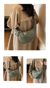 Detail showing an olive green nylon crescent bag with adjustable strap and braided zipper pulls