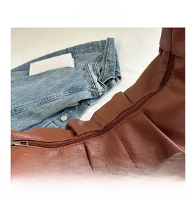 Detail of dark brown lychee leather texture and metal zipper on the cloud bag