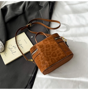Detail einer braunen Wildleder-Beuteltasche mit Leopardenmuster und Goldbeschlägen