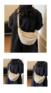 Detail of oat nylon crescent crossbody bag with woven zipper pull on black coat