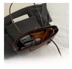 Top view of the brown tote bag interior showing spacious capacity for books and phone