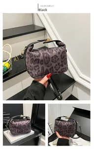 Détail du sac polochon léopard avec poignée en cuir noir et fermoir en métal doré