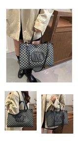 Detail view of black jacquard tote bag with M monogram and large oval logo detail