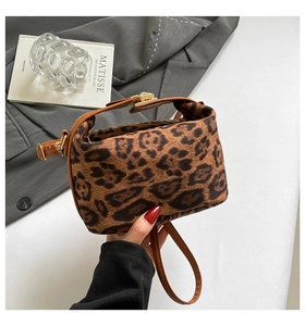 Gros plan du sac bandoulière léopard avec boucle dorée et lanière en cuir marron
