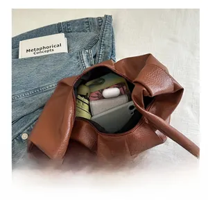 Interior storage space of brown textured PU leather bag with daily essentials inside