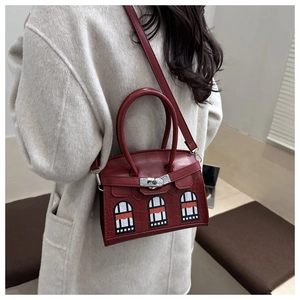 Detail of red faux leather handbag with crocodile pattern and window-shaped patch designs