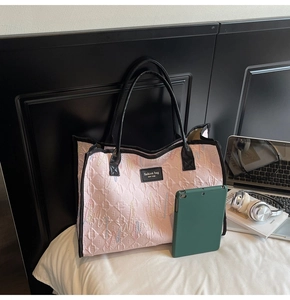 Macro detail of pink quilted tote bag with wave embroidery and black fashion label