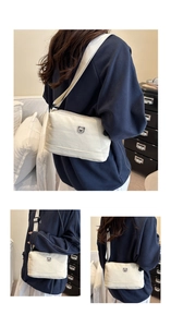 Detail of a cream canvas crossbody bag featuring a cute small bear embroidery and wide strap